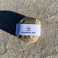 Kystnær shampoo med aktivt kul på en strand